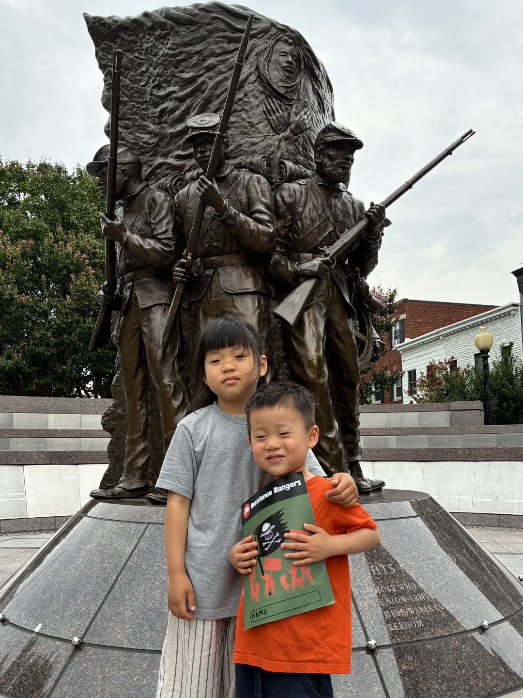 children holding Resistance Rangers booklet outside of monument