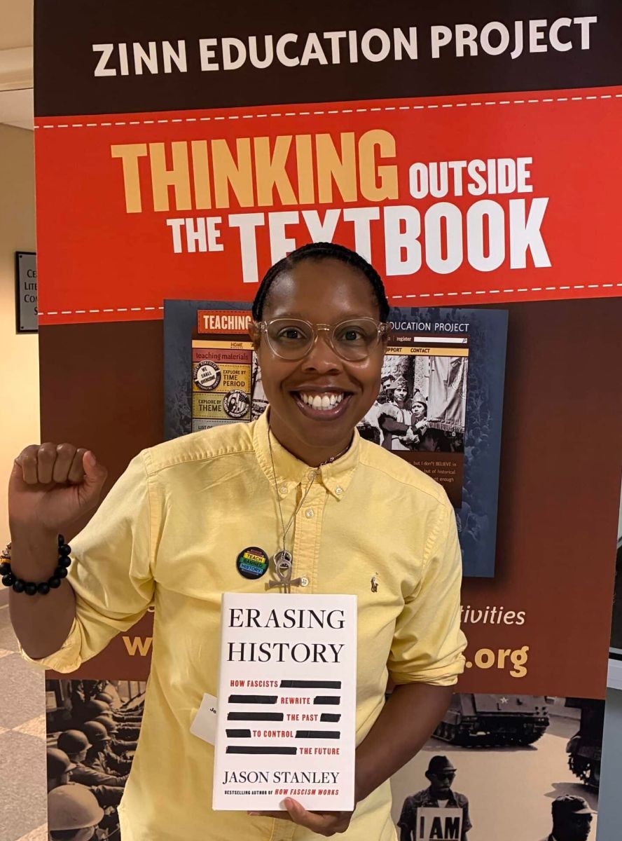 woman holding Erasing History in yellow shirt with fist pump